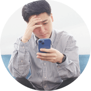 スマホを見ながら頭を抱える男性